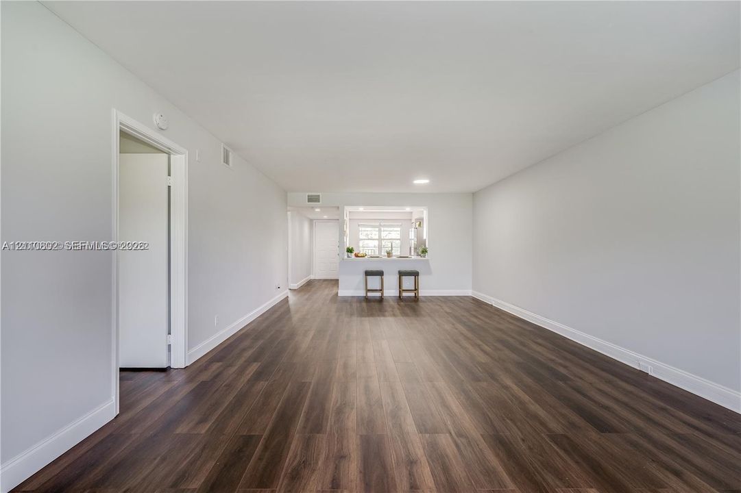 Open-concept interior featuring wood-finish flooring, recessed lighting, and a kitchen pass-through counter