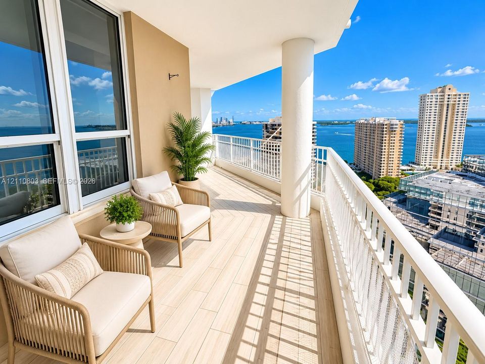 Covered balcony featuring wood-finish tile flooring, white metal railing, and expansive water and urban skyline scenery