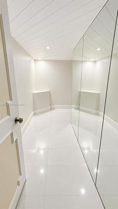 Glossy tile flooring, shiplap ceiling, full-length wall mirror, and recessed lighting