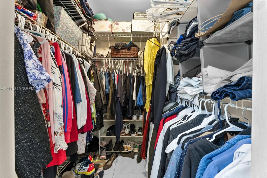 Walk-in closet featuring multi-level white wire shelving and integrated vertical storage compartments