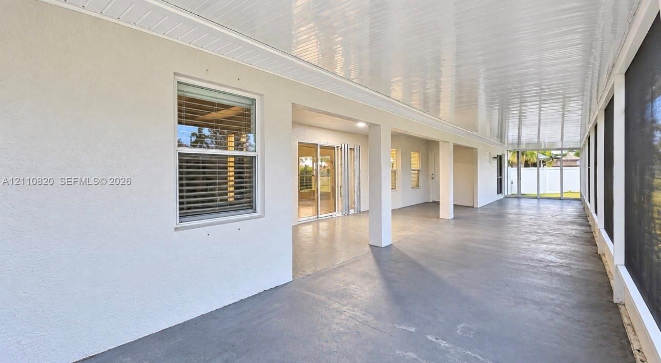 Covered, screened-in lanai featuring a solid concrete floor, recessed ceiling lighting, and exterior access via sliding glass doors