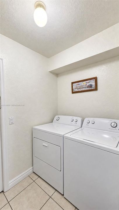 Laundry utility area featuring tiled flooring and a flush-mount ceiling light fixture