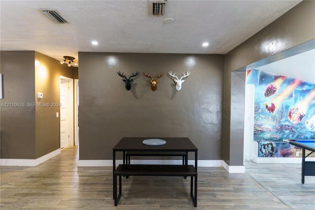 Open-concept interior featuring wood-finish flooring, recessed lighting, and a multi-directional track lighting fixture