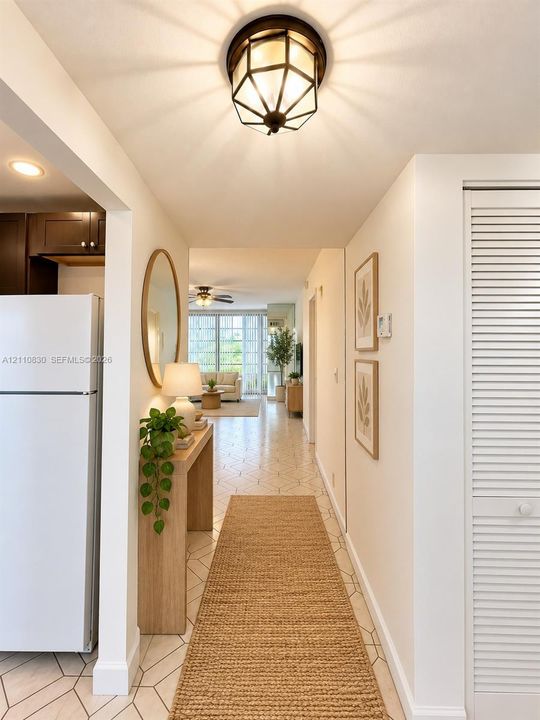 STAGED Hallway featuring geometric tile flooring, a multi-faceted flush-mount light fixture, and floor-to-ceiling louvered closet doors