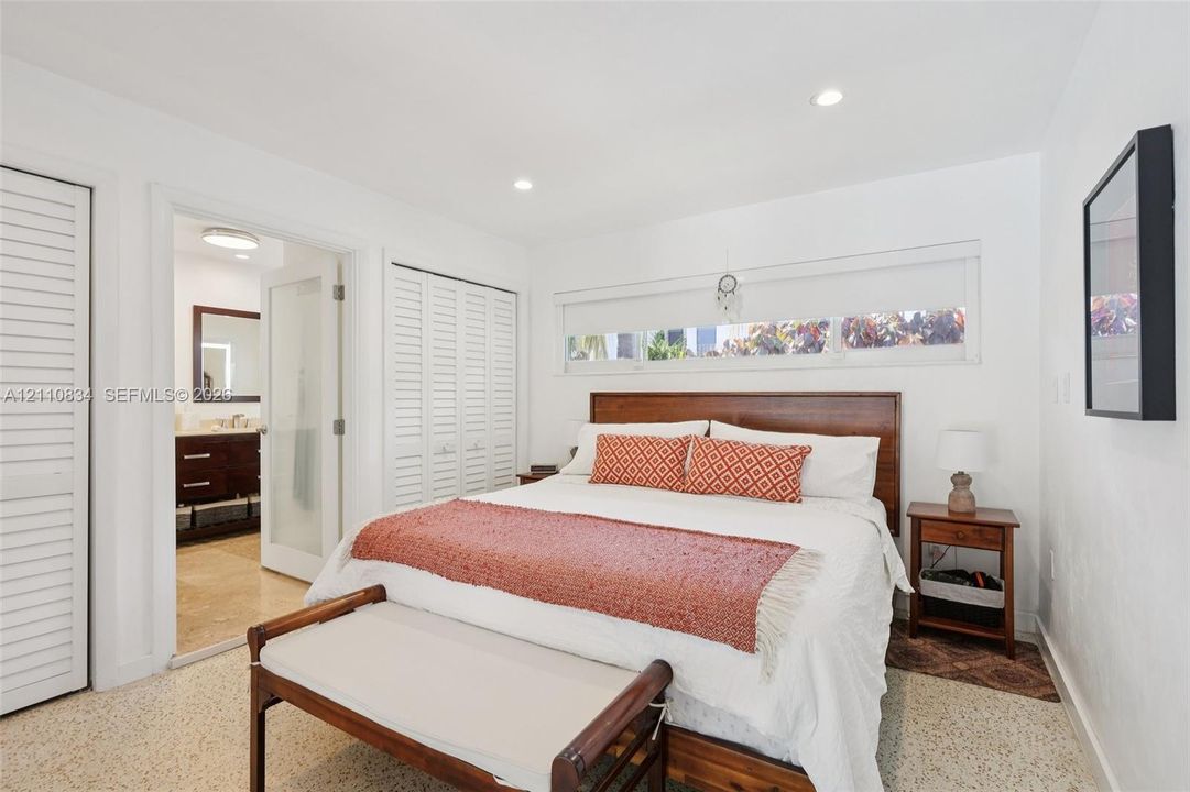 Terrazzo flooring, recessed ceiling lighting, horizontal clerestory window, and louvered-style closet doors