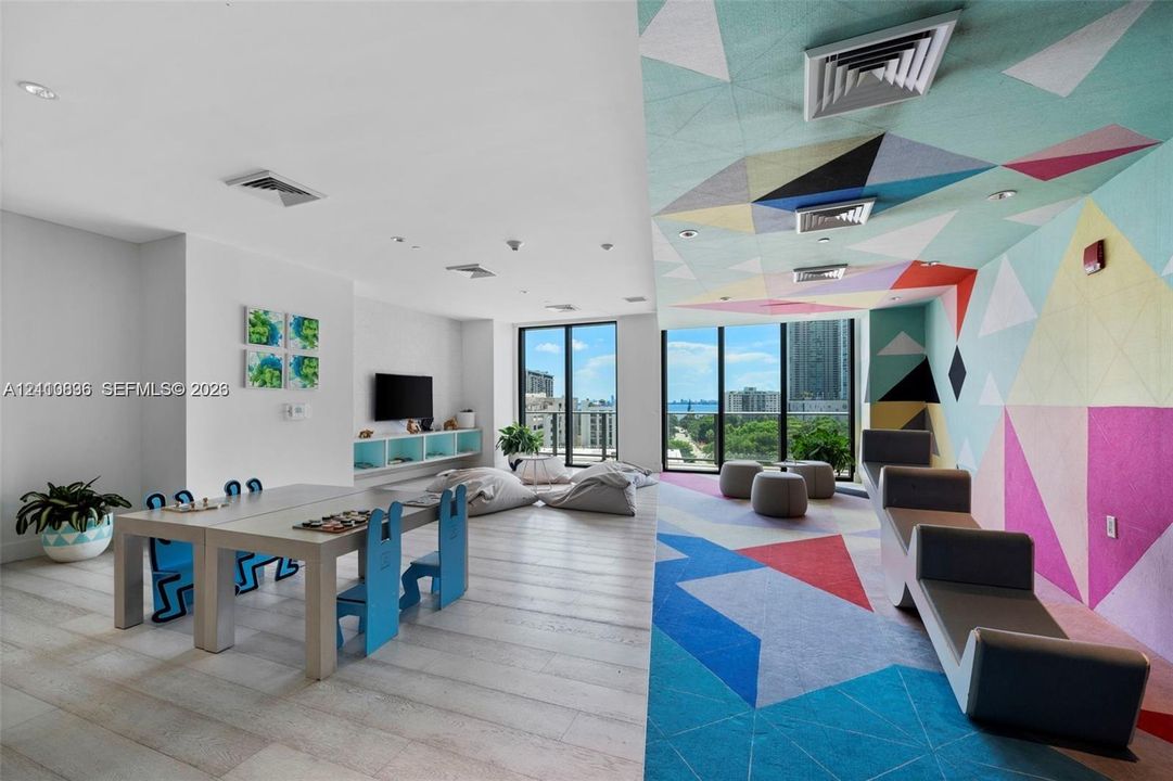 Large interior space featuring wood-finish flooring, floor-to-ceiling windows, and recessed lighting