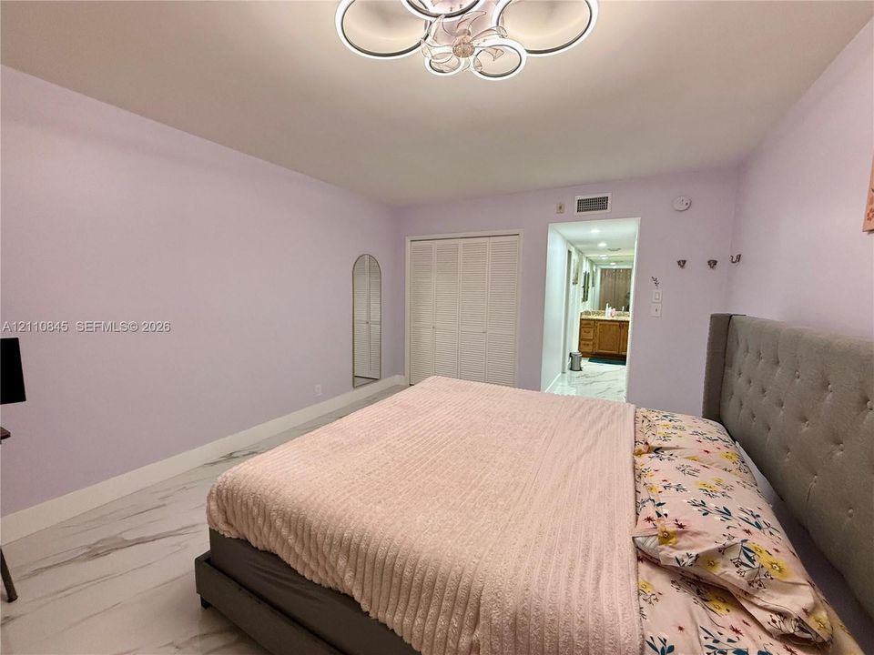Large-format tile flooring, multi-light contemporary ceiling fixture, and dual bi-fold closet doors