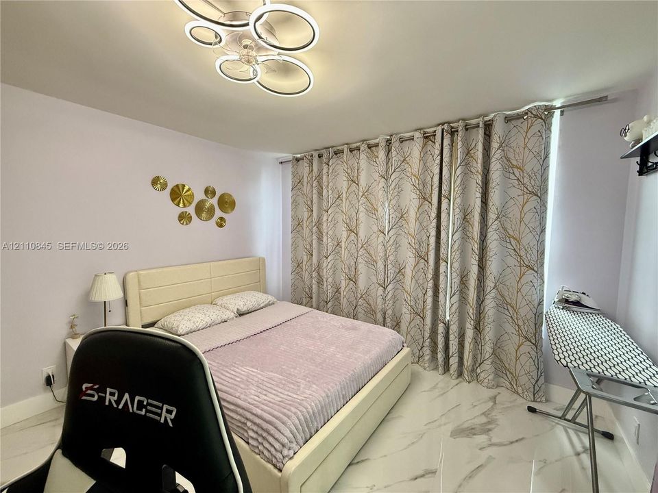 Contemporary multi-ring LED flush-mount ceiling light and polished stone-finish flooring
