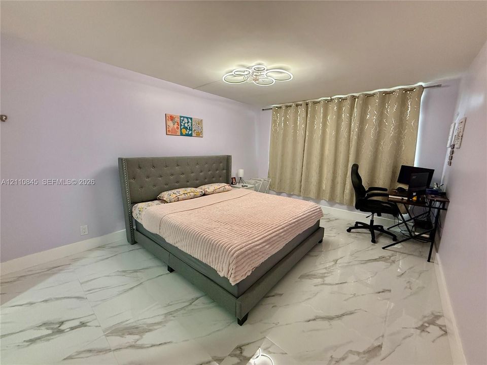 Polished large-format floor tile with stone-patterned veining and modern circular flush-mount ceiling lighting