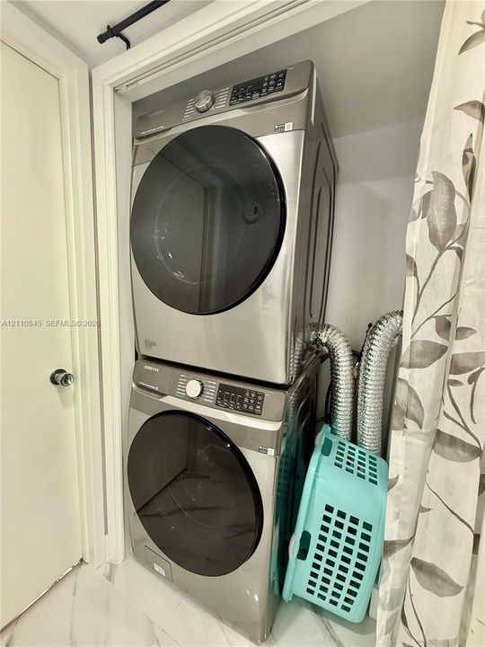 Stacked front-load washer and dryer in stainless steel finish with digital control panels