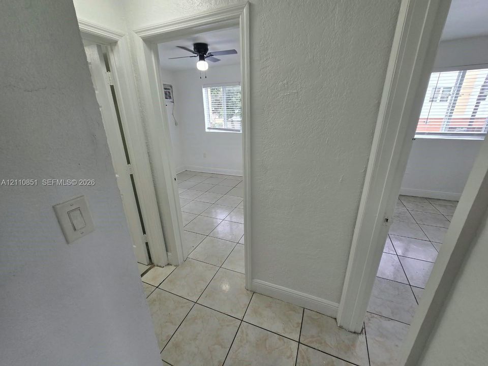 Neutral-toned interior with tile flooring and ceiling-mounted light fixtures