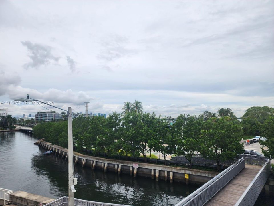 Waterfront bulkhead with an elevated pedestrian walkway featuring wood-finish decking and metal railings