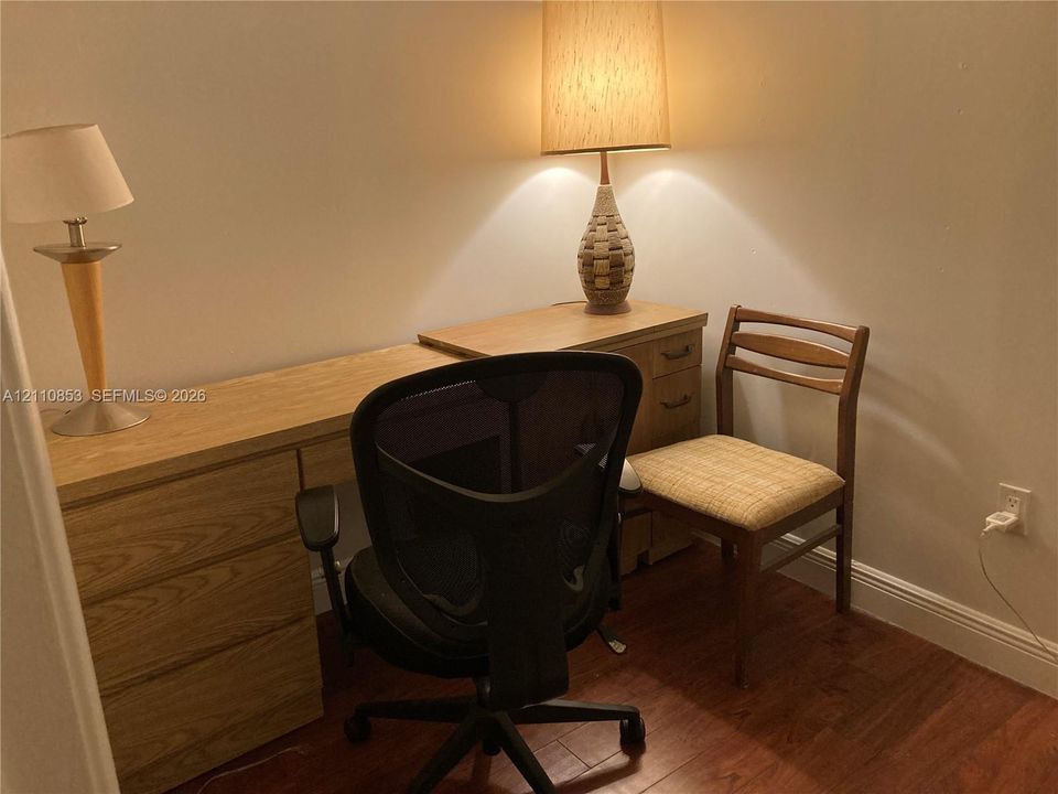 Built-in light-oak desk with integrated drawer storage and wood-finish flooring