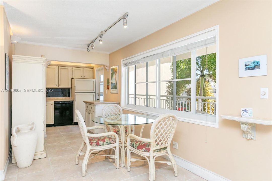 Kitchen featuring light-toned cabinetry, ceramic tile flooring, horizontal sliding windows, and adjustable track lighting