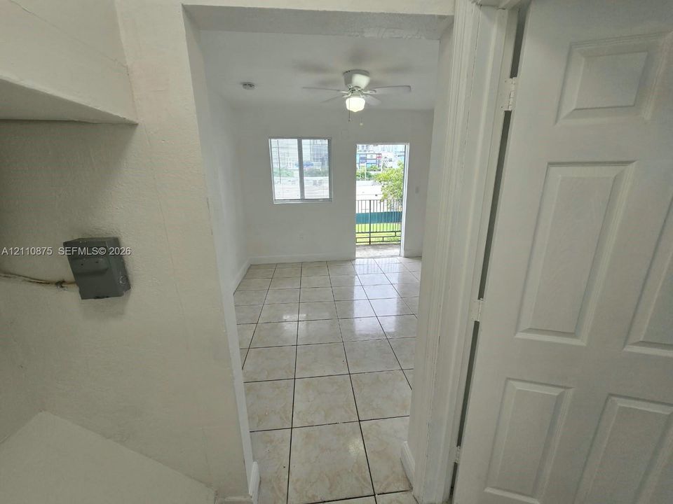 Interior space featuring ceramic tile flooring, a central ceiling fan with integrated lighting, and a glass-paneled exterior door