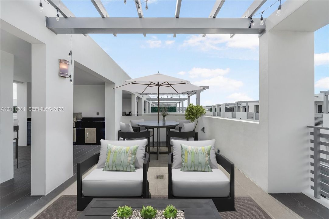 Rooftop terrace featuring a pergola, tiled flooring, integrated outdoor kitchen with dark stone countertops, and a solid wall enclosure
