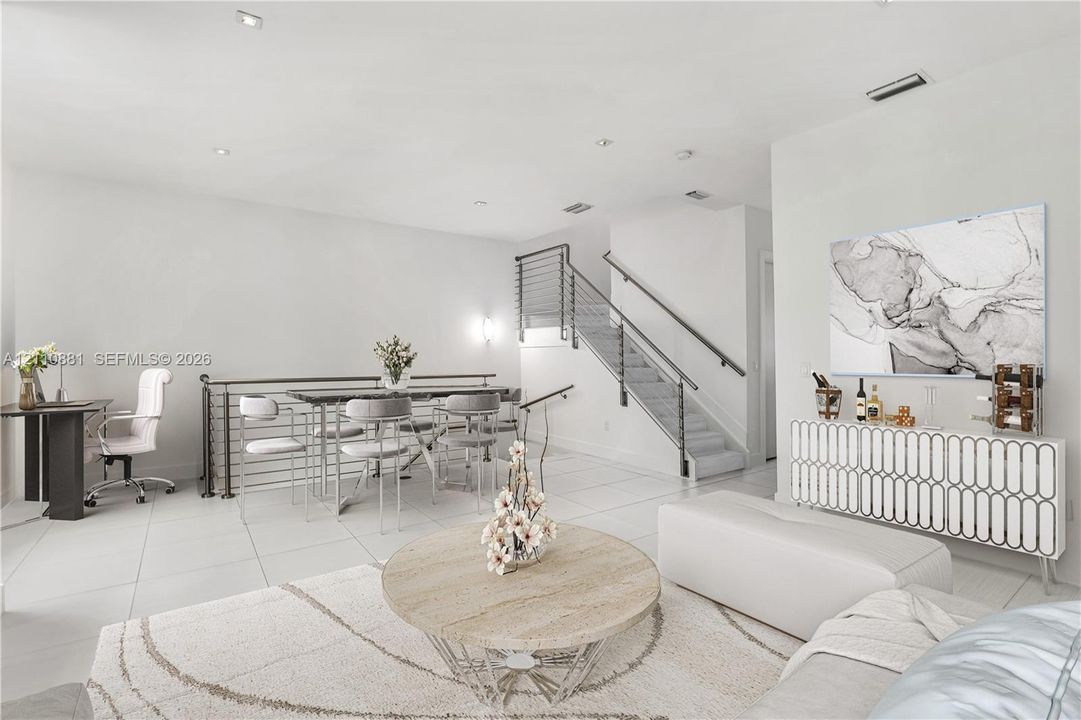 Open-concept interior featuring large-format tile flooring, recessed ceiling lighting, and a staircase with stainless steel horizontal cable railing