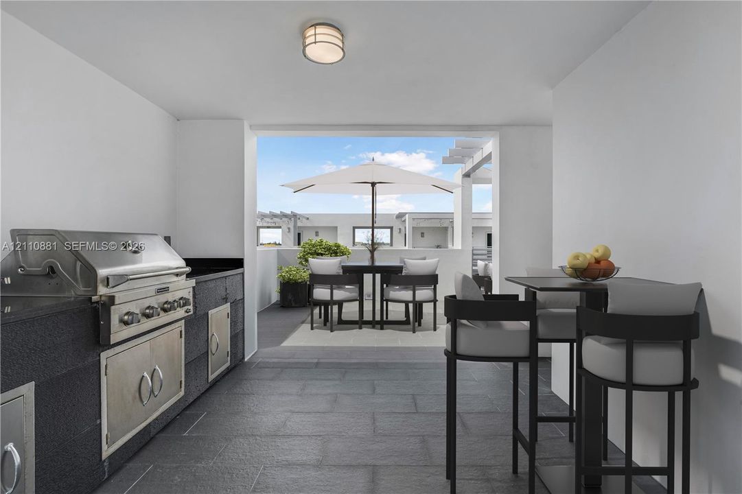 Outdoor kitchen featuring stone tile flooring, stainless steel built-in grill, dark stone countertop, and cabinetry with stainless steel hardware