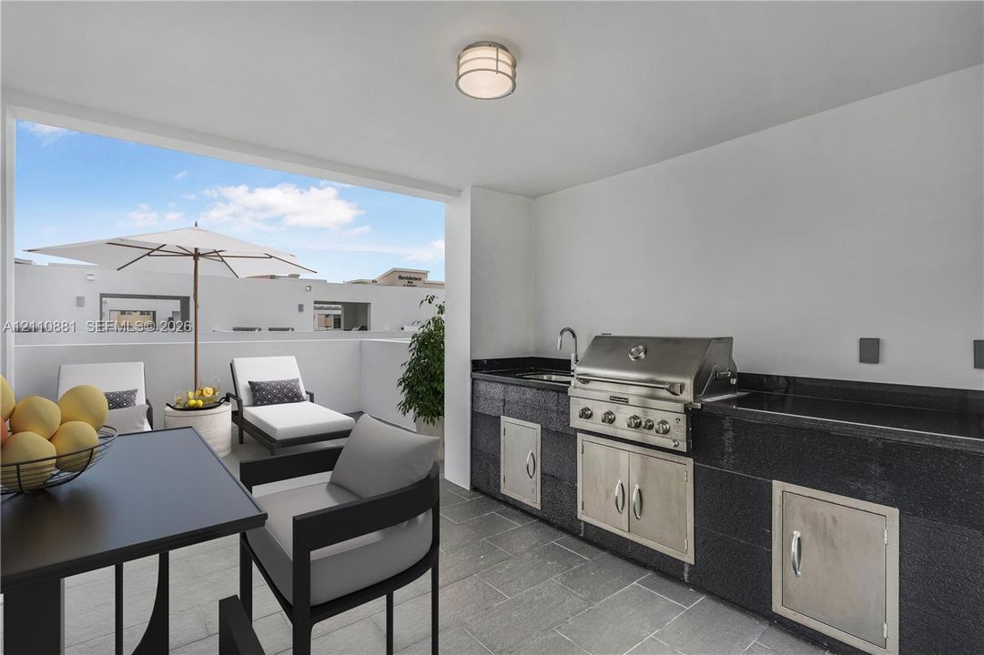Covered outdoor kitchen featuring stone countertops, integrated stainless steel grill, stainless steel cabinetry, and tile flooring