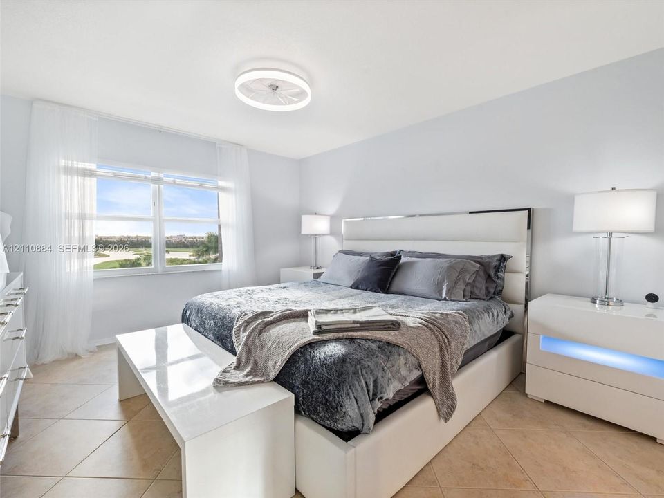 Large-format tile flooring, brand new impact dual-pane windows, and a low-profile dimmable circular LED ceiling fixture and fan combination