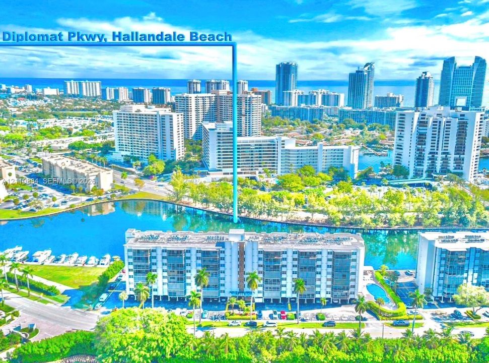 Aerial perspective of Diplomat Parkway featuring waterfront proximity, expansive waterway frontage, mature palm trees, and multi-story residential architecture
