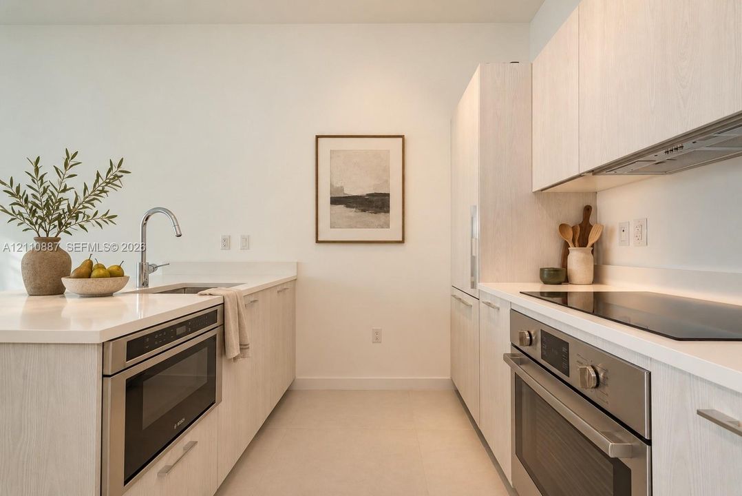 Kitchen featuring light-finish cabinetry, solid-surface countertops, stainless steel wall oven, flat-surface cooktop, and built-in microwave