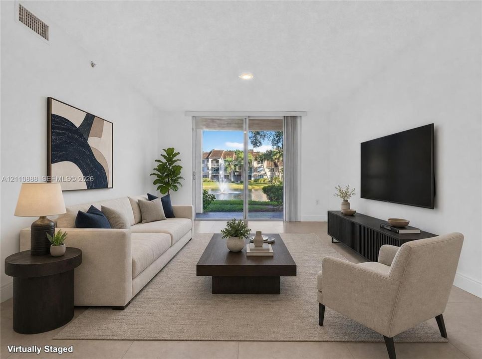 Living area featuring tile flooring, neutral paint, and sliding glass doors opening to an exterior terrace with water scenery