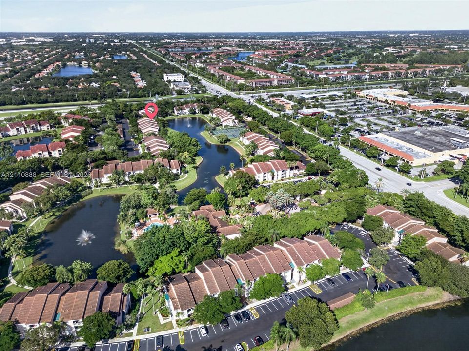 Aerial perspective of a multi-unit residential community featuring clay tile rooflines, interconnected water features, fountain elements, and mature landscaping