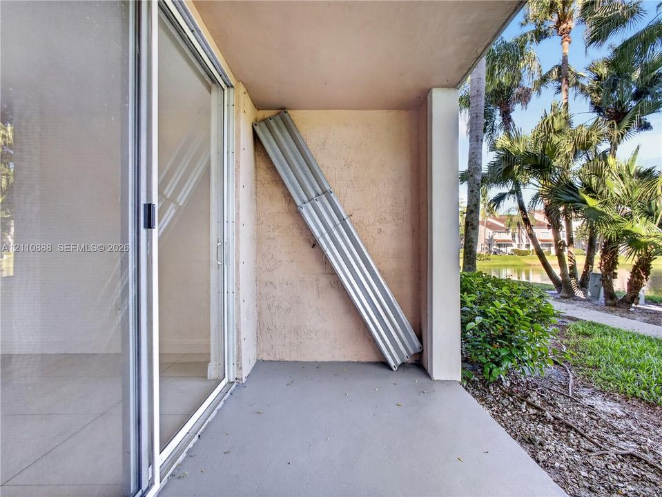Covered patio featuring concrete flooring, stucco walls, and sliding glass door entry