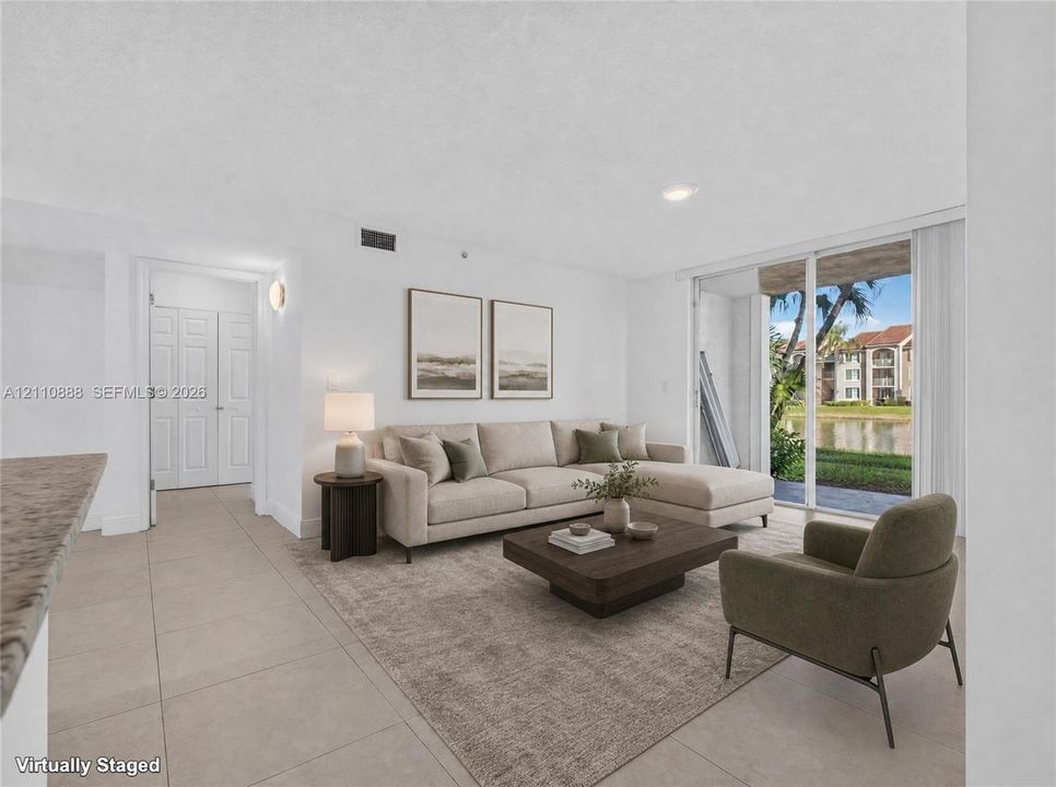Living area featuring large-format ceramic tile flooring, recessed lighting, and full-height sliding glass doors providing access to the exterior