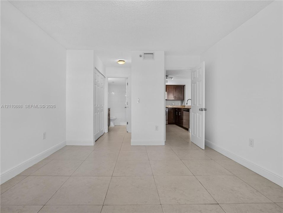 Neutral-toned tile flooring, six-panel interior doors, and crisp white wall finishes