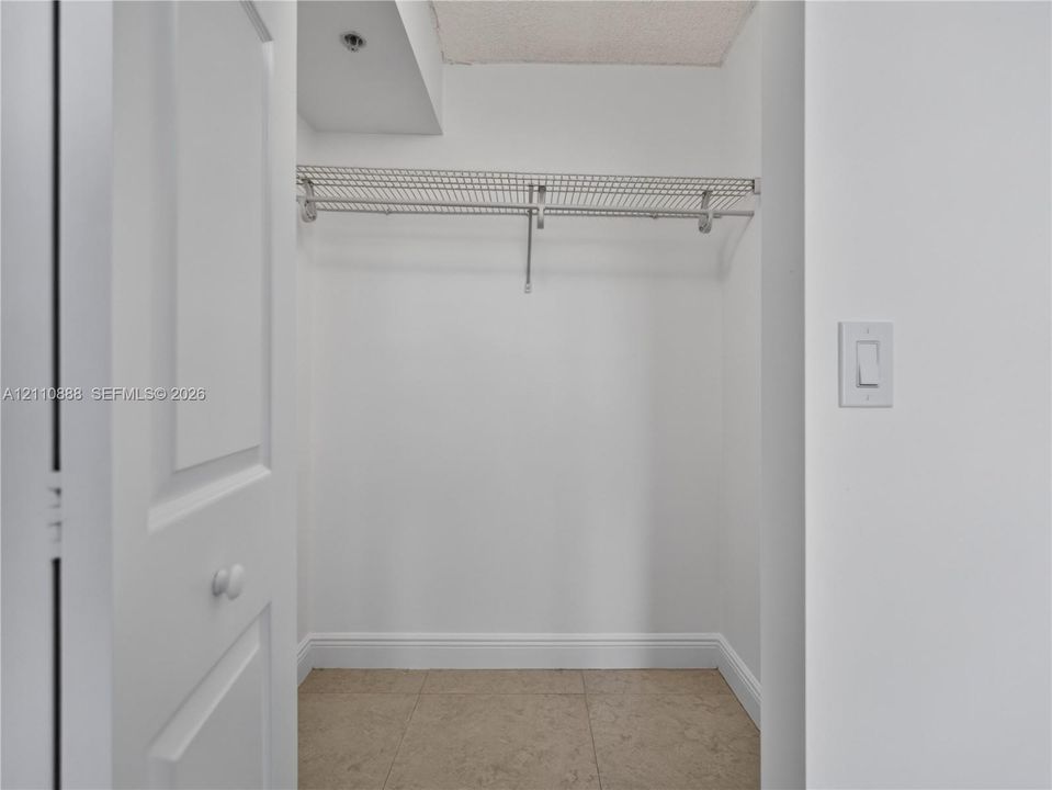Storage area featuring wire shelving and neutral tile flooring