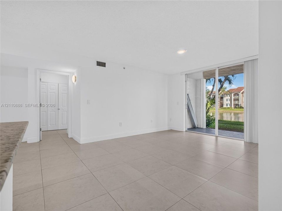Large-format ceramic tile flooring, sliding glass door, recessed lighting, and built-in closet with multi-panel doors