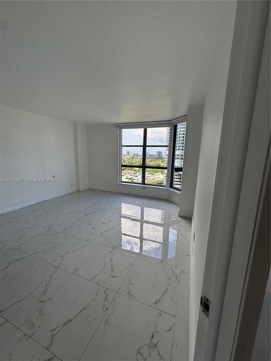 Large-format polished tile flooring, floor-to-ceiling windows with grid detailing, and panoramic urban scenery
