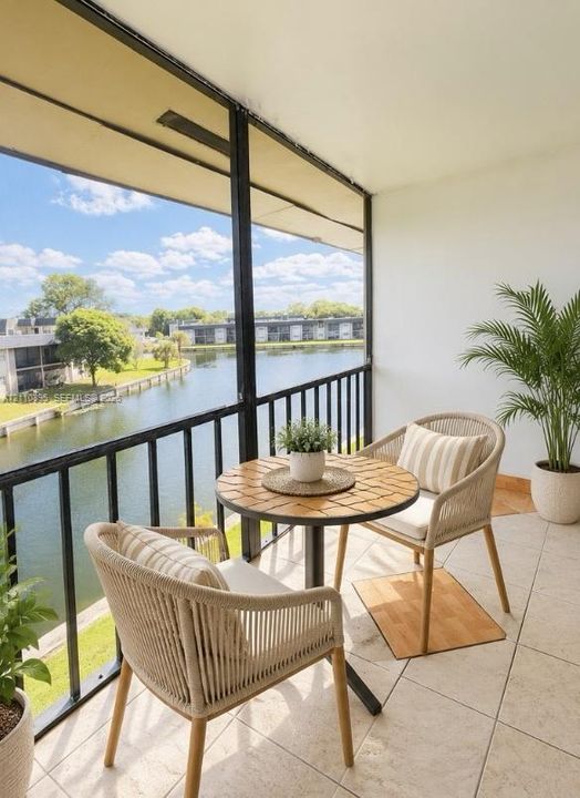 Screened-in balcony featuring tile flooring, metal railings, and direct water exposure
