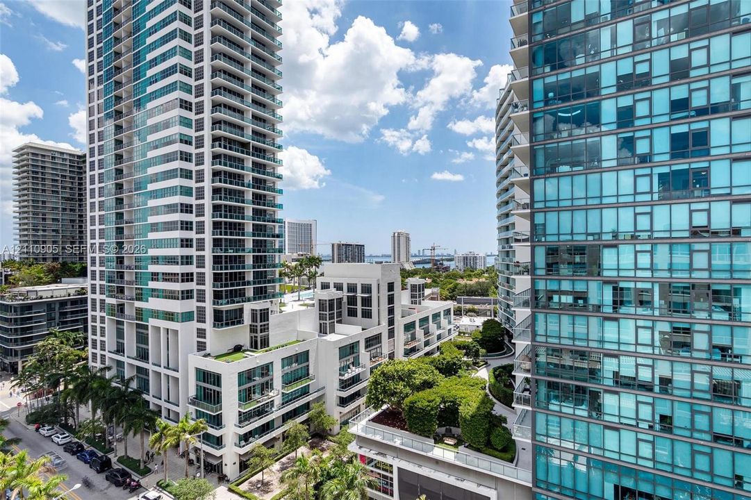 High-rise urban architecture featuring floor-to-ceiling glass paneling, tiered balconies, and integrated landscaped terraces