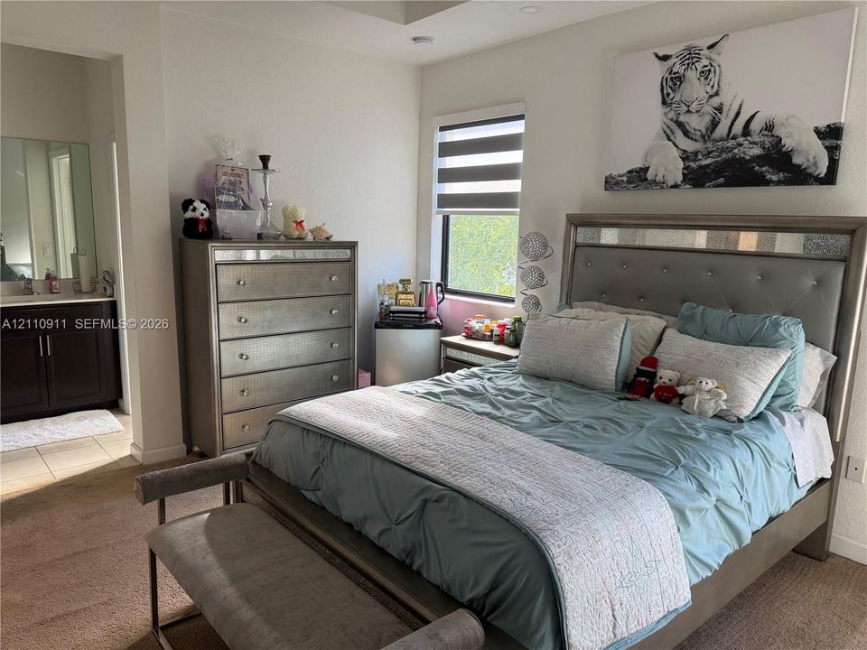 Neutral-toned carpeting, recessed ceiling lighting, and a window with motorized shade functionality