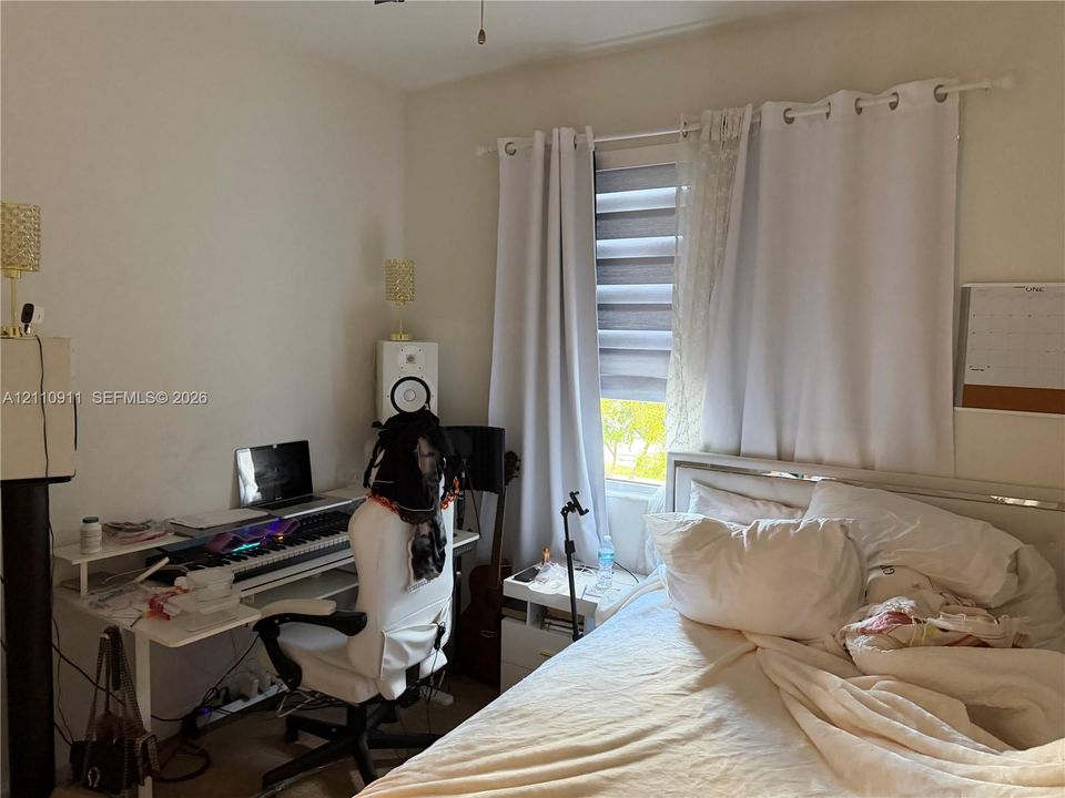 Room interior featuring neutral walls, a multi-textured window treatment with integrated roller shade, and a ceiling-mounted light fixture