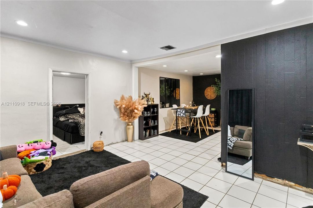 Interior space featuring white ceramic tile flooring, recessed lighting, and a prominent black wood-textured accent wall