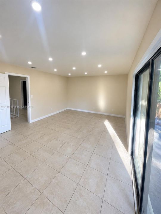 Interior space featuring large-format ceramic tile flooring, recessed ceiling lighting, and expansive glass sliding doors