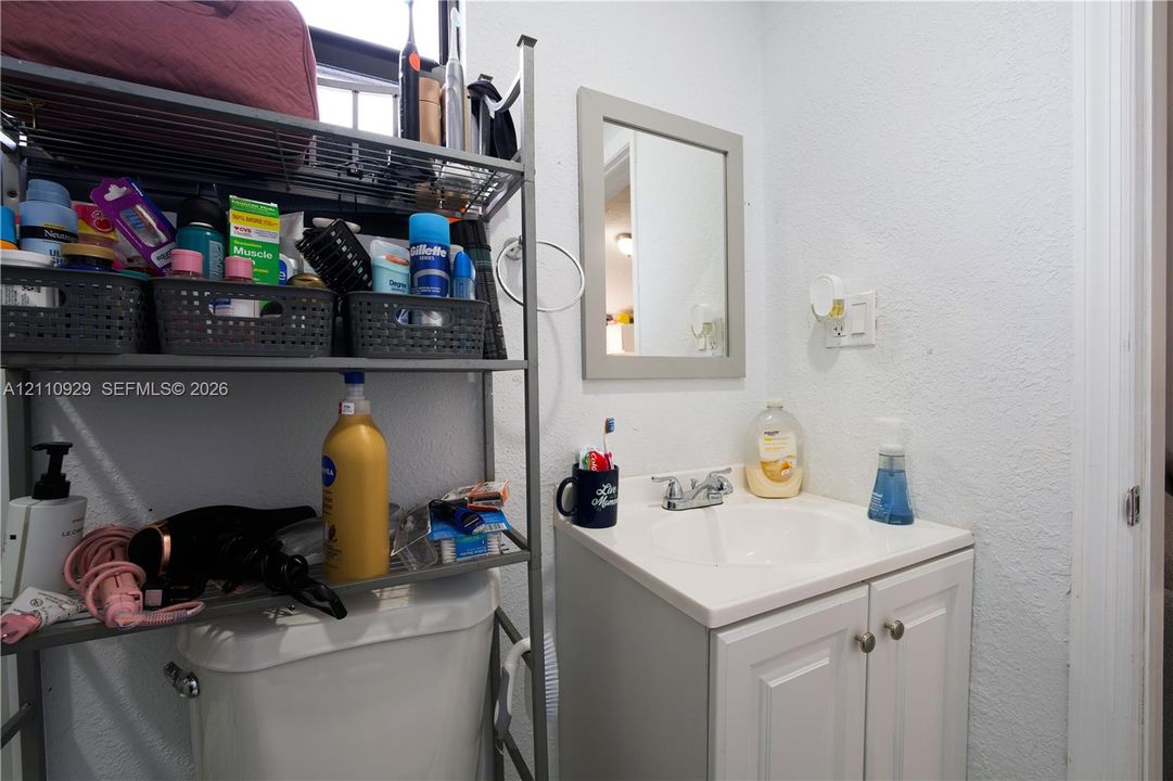 White vanity cabinet with an integrated basin, dual-handle chrome faucet, and framed wall mirror