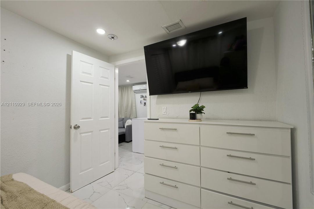 Interior space featuring polished stone-finish tile flooring, recessed ceiling lighting, and a solid-core panel door