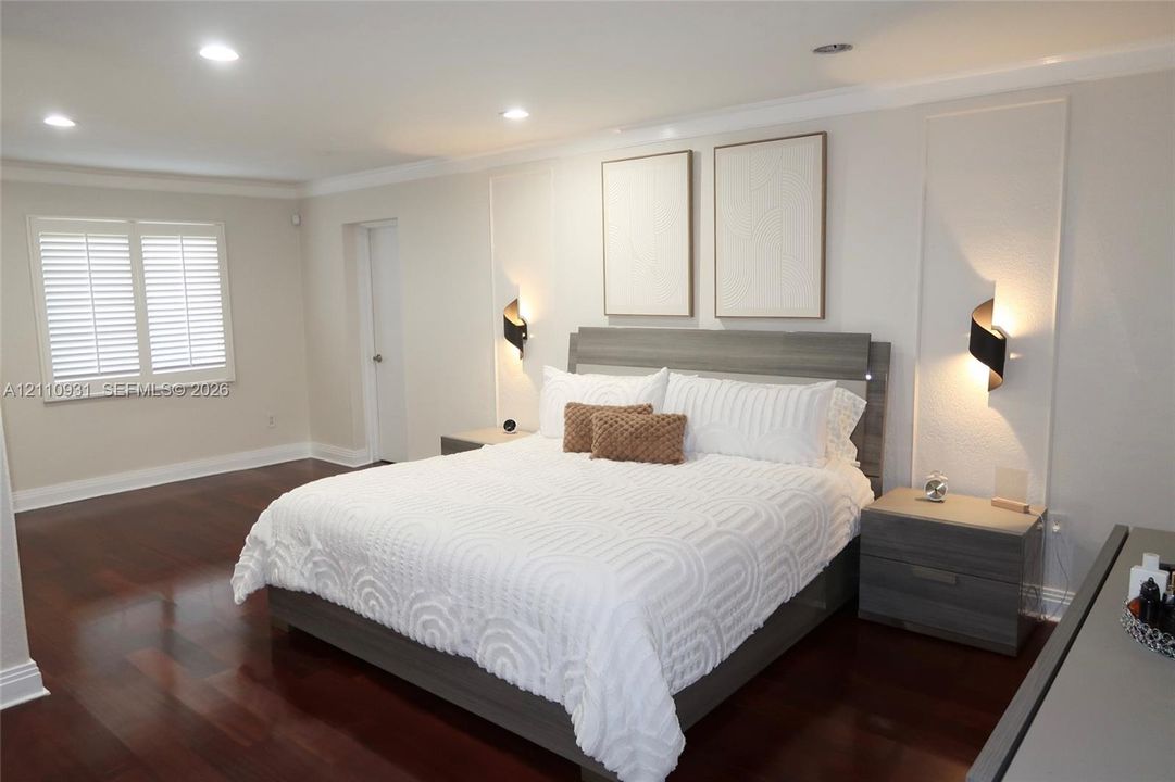Hardwood flooring, recessed lighting, wall-mounted accent lighting, framed wall paneling, and shutter-style window coverings