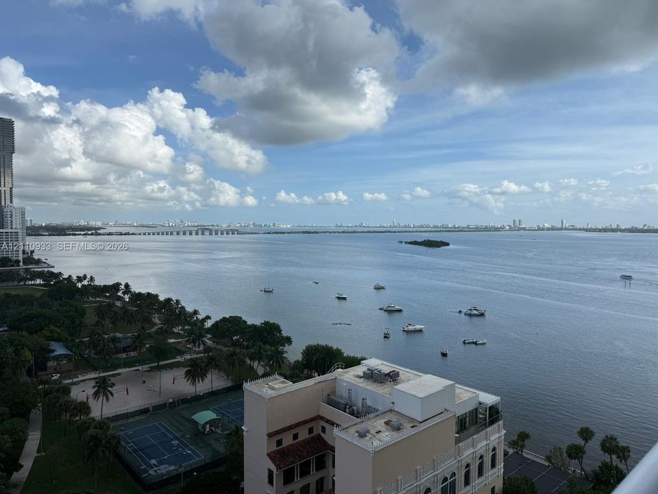 High-elevation perspective of the waterfront, featuring a bay, moored vessels, and a cityscape horizon