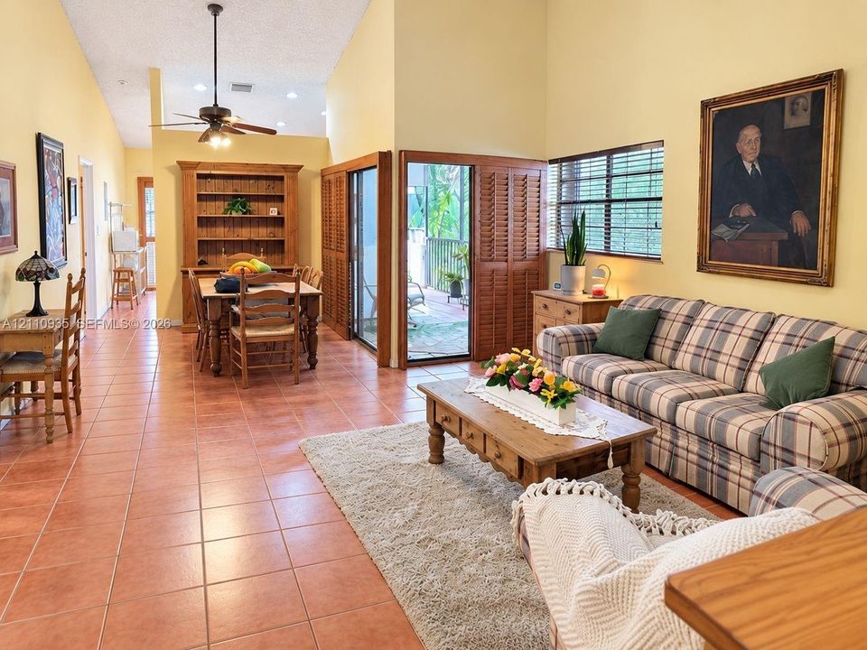 Vaulted ceilings, ceramic tile flooring, wood-finish built-in cabinetry, and dual sets of louvered glass sliding doors