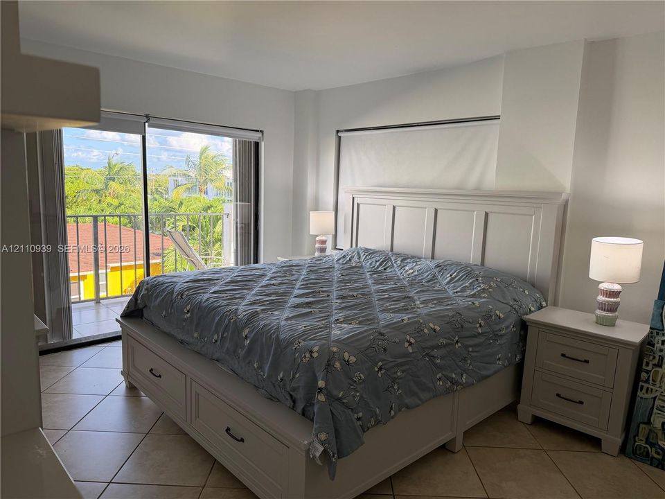 Ceramic tile flooring, neutral wall tones, and glass sliding doors opening to a balcony
