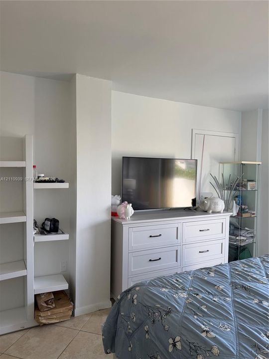 Built-in white shelving unit and large-format tile flooring