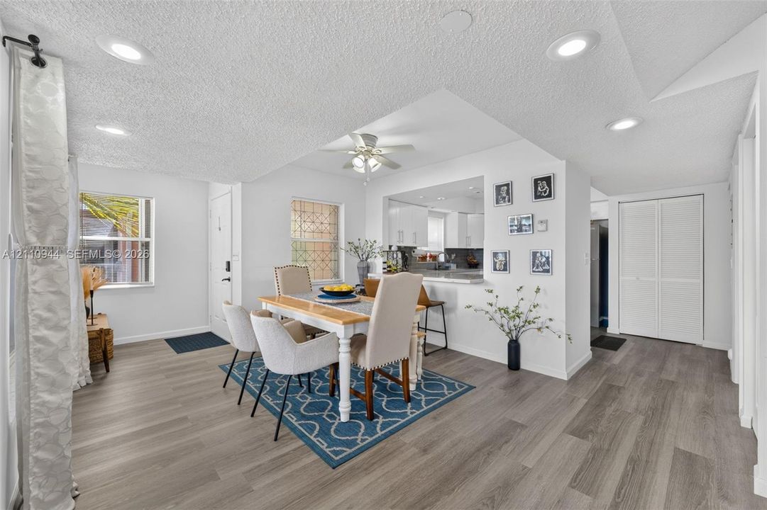 Open-concept area featuring wood-finish flooring, recessed lighting, a ceiling fan, and double-door closet cabinetry