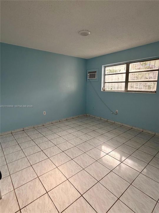 Interior space featuring ceramic tile flooring, neutral wall tones, multi-pane windows, and a recessed ceiling lighting fixture