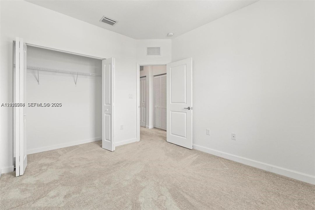 Neutral interior featuring neutral-toned carpeting, bi-fold closet doors, and multi-panel interior doors
